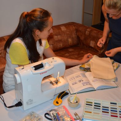 The sewing tutor teaching her student